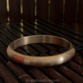 Brass kada round front view on brown wooden surface