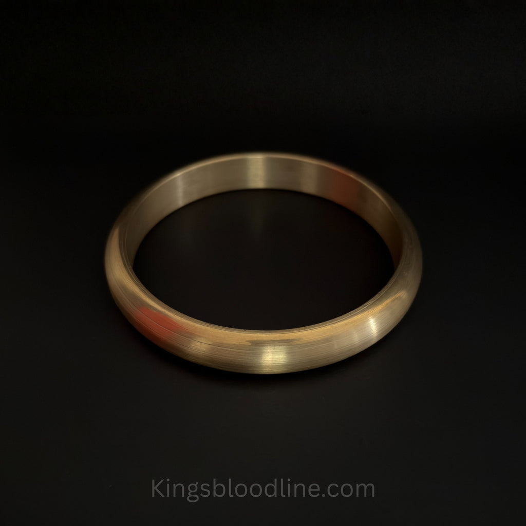 Brass kada round on black surface