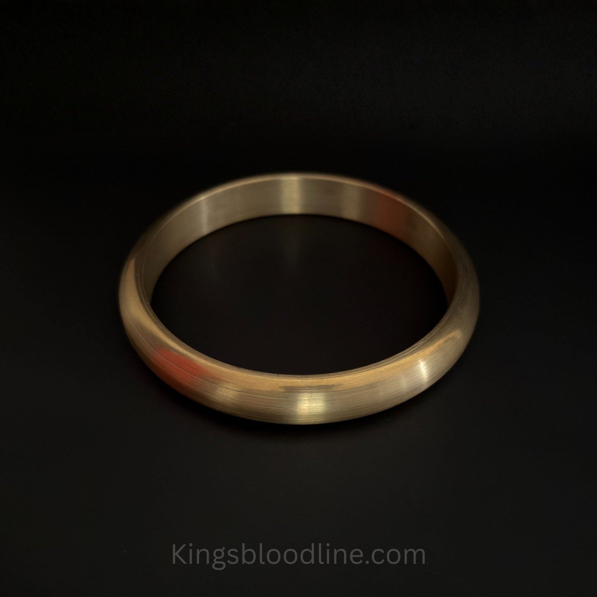 Brass kada round on black surface