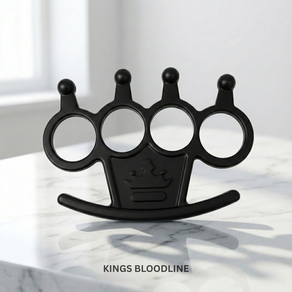 Black knuckle duster with a crown emblem on a marble surface, branded 'Kings Bloodline'.
