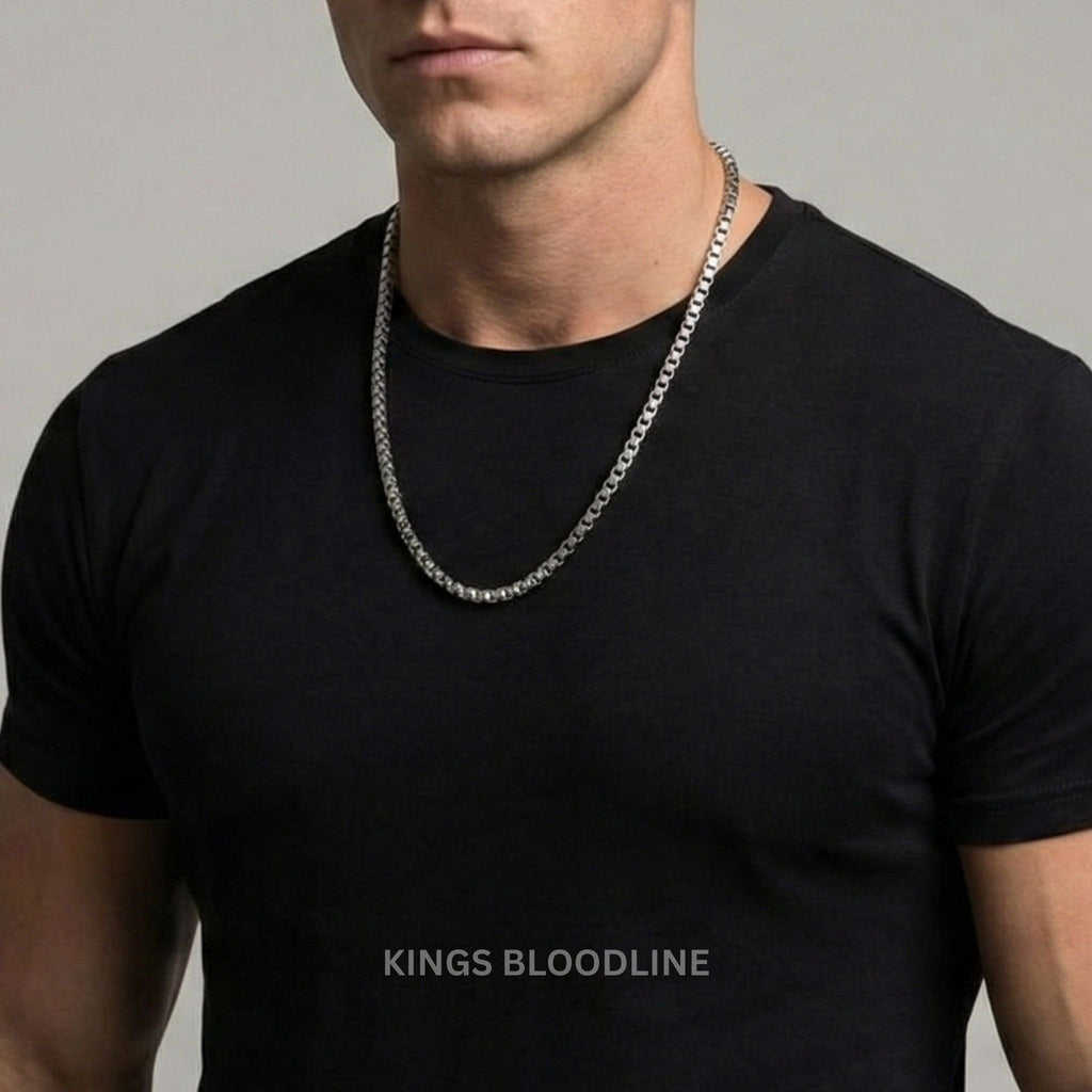 Man wearing a black t-shirt with a silver chain necklace on a gray background, featuring 'Kings Bloodline' branding.