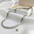 Silver Box chain on white fabric