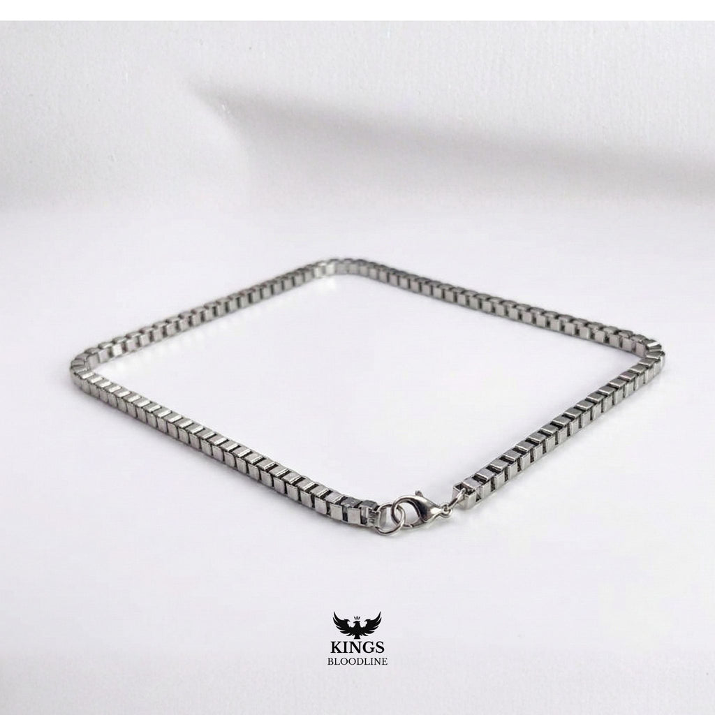Silver Box chain on white table