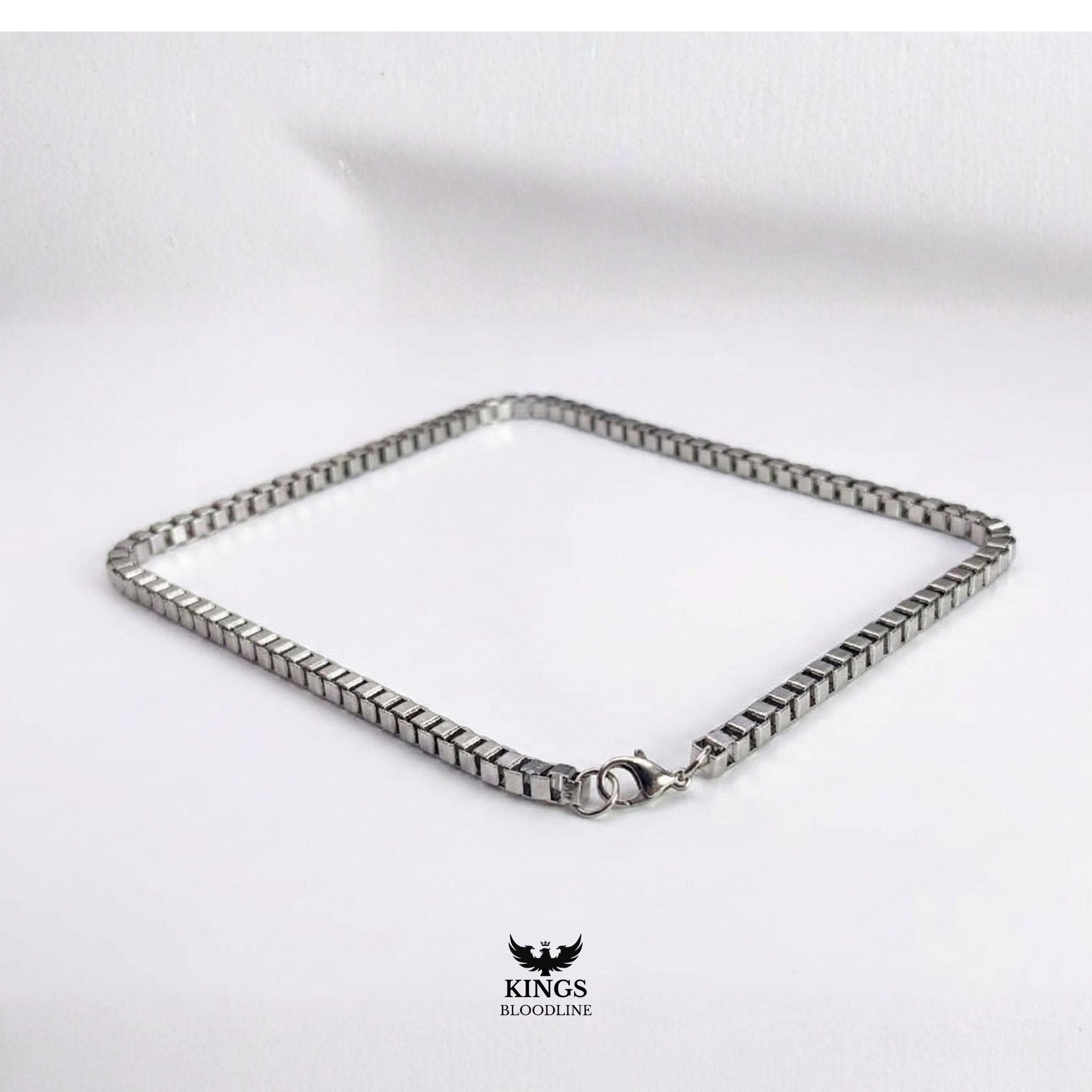 Silver Box chain on white table