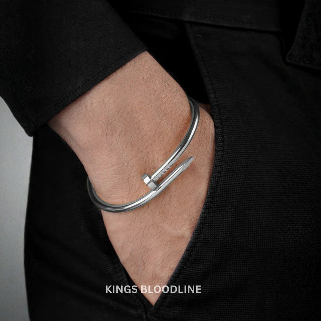 Silver bracelet on a wrist with a black background